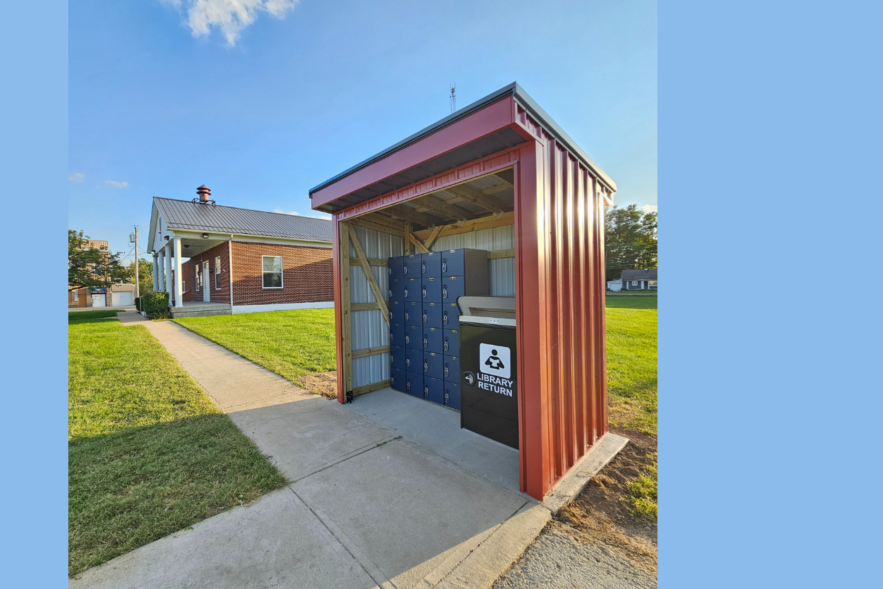 24/7 Pickup Locker and drop off shelter with Bloomingburg village hall in the background.